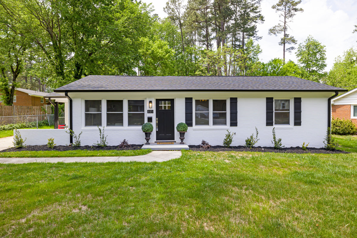 Original photograph of a white ranch home with dark shutters and a small side porch