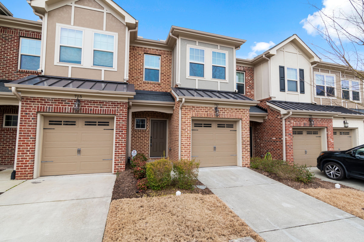 Original photograph of adjoining townhomes · The artwork depicts the central home with a gray upper bay and garage